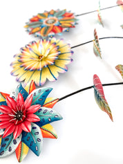 Colorful flower-shaped garden stakes on a white background.