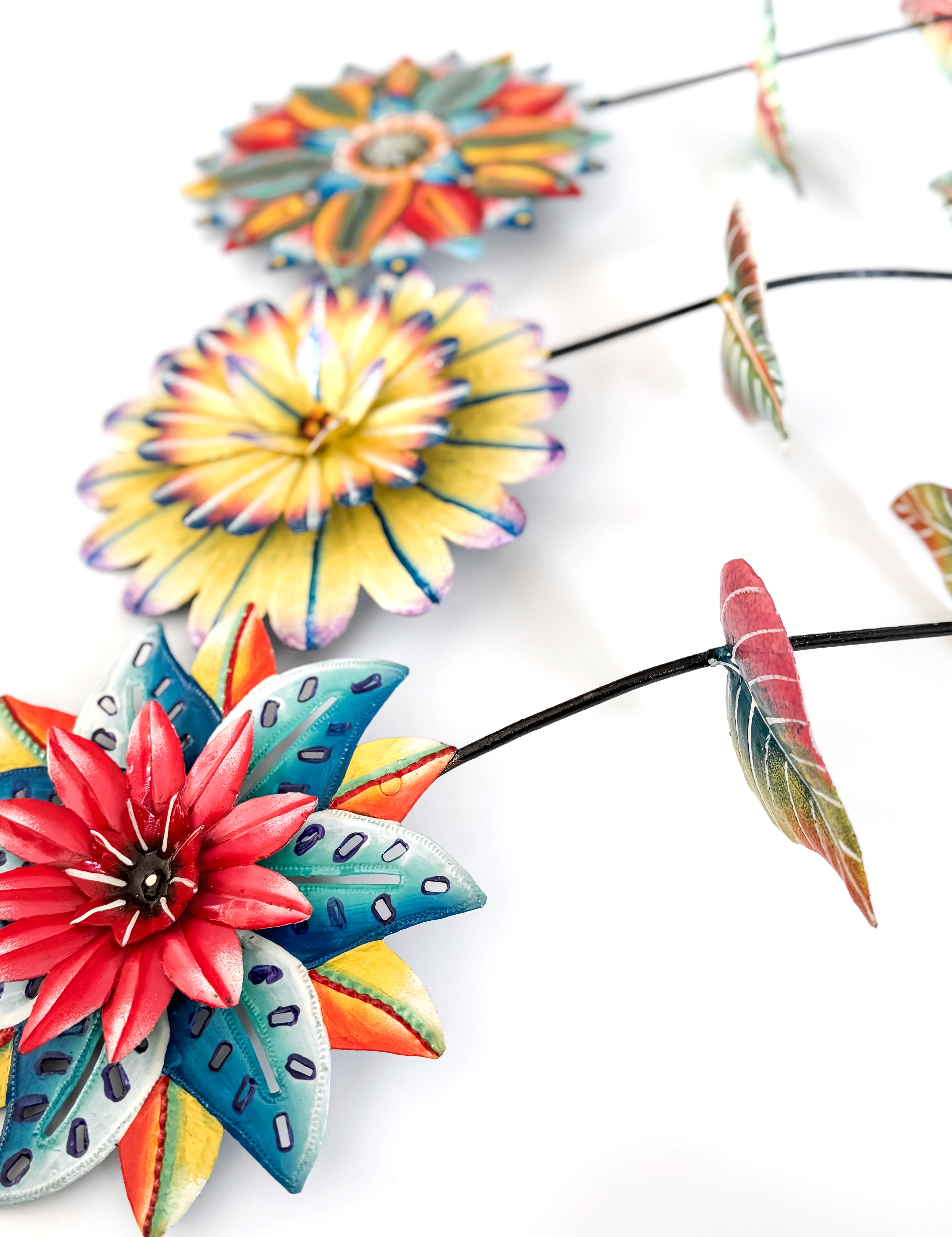 Colorful flower-shaped garden stakes on a white background.
