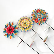 Colorful flower-shaped garden stakes on a white background.