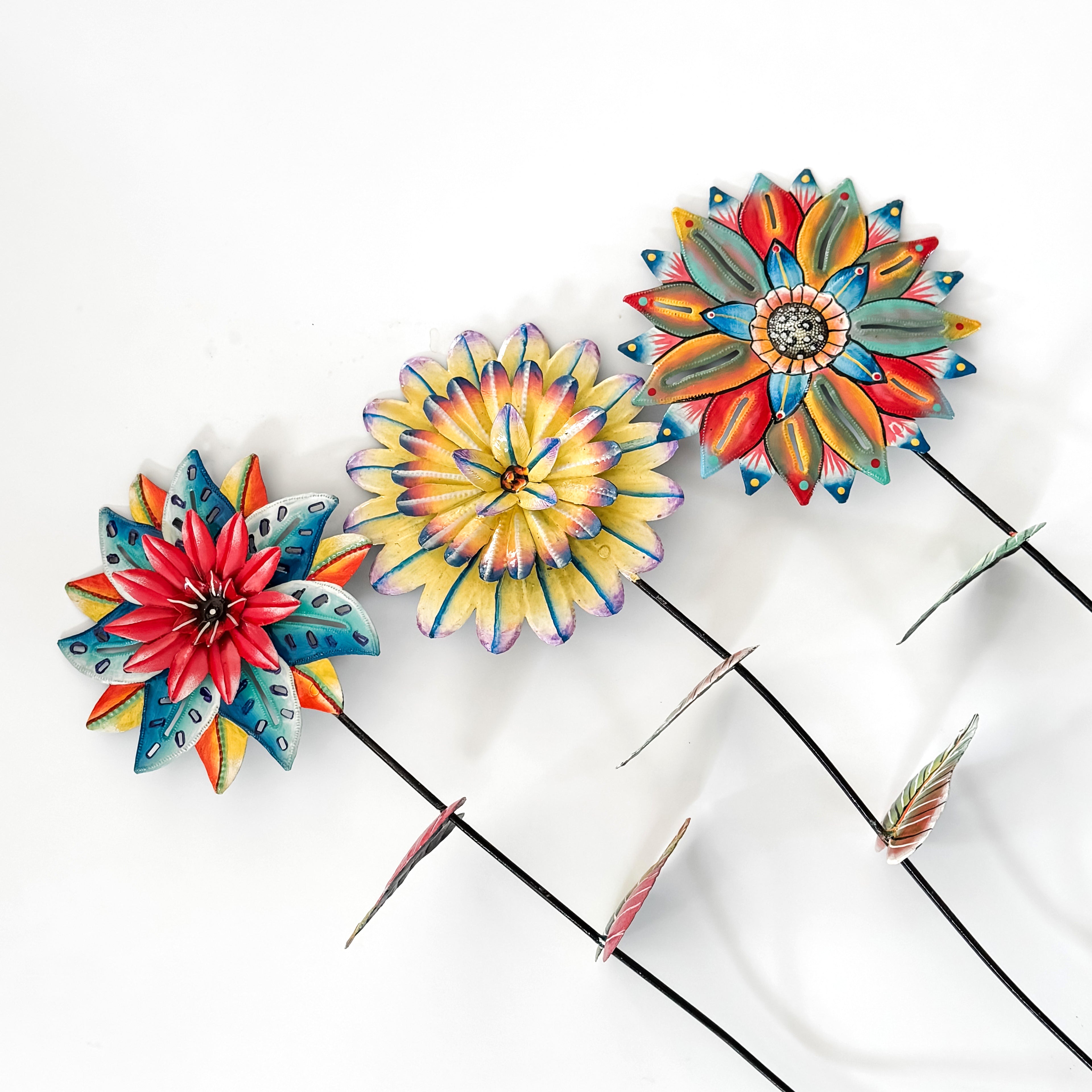 Colorful flower-shaped garden stakes on a white background.