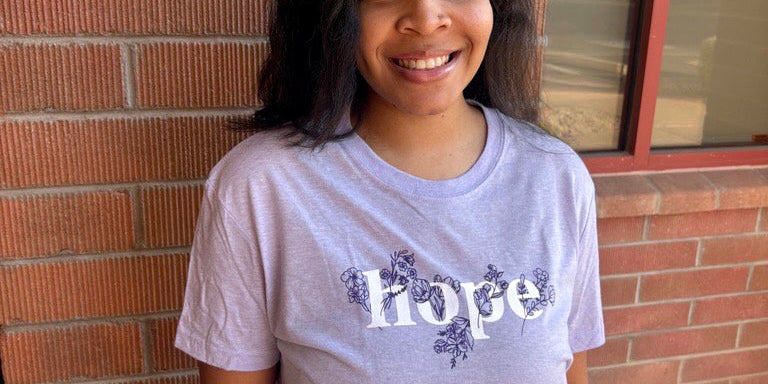 Person wearing a 'Hope' t-shirt standing in front of a brick wall.