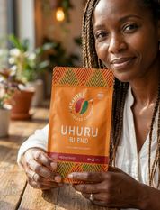 Woman holding a bag of Asante Uhuru Blend coffee.