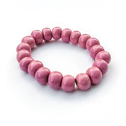 A pink beaded stretch bracelet made of smooth, glossy round clay beads, photographed on a clean white background.