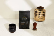 Avanti coffee package with a wooden tamp and glass container on a white surface