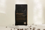 Black coffee packaging with text and a QR code on a white background