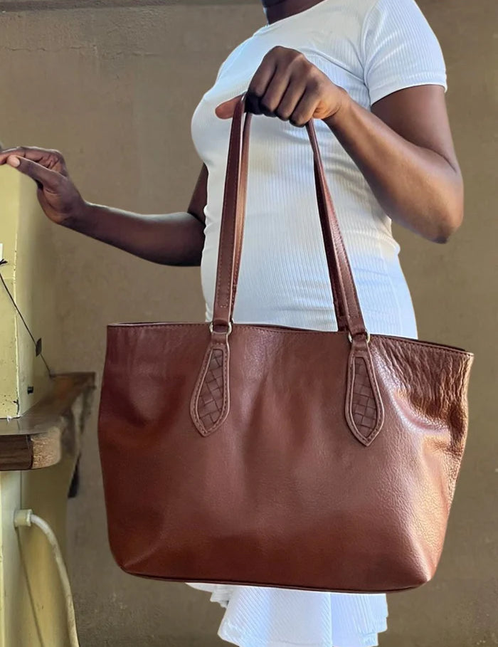 mid-tote-brown-held-by-haitian-artisan-fall-collection-lifestyle-close-up_jpg.webp