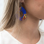 Model wearing beaded teardrop earrings made by artisans in Kenya